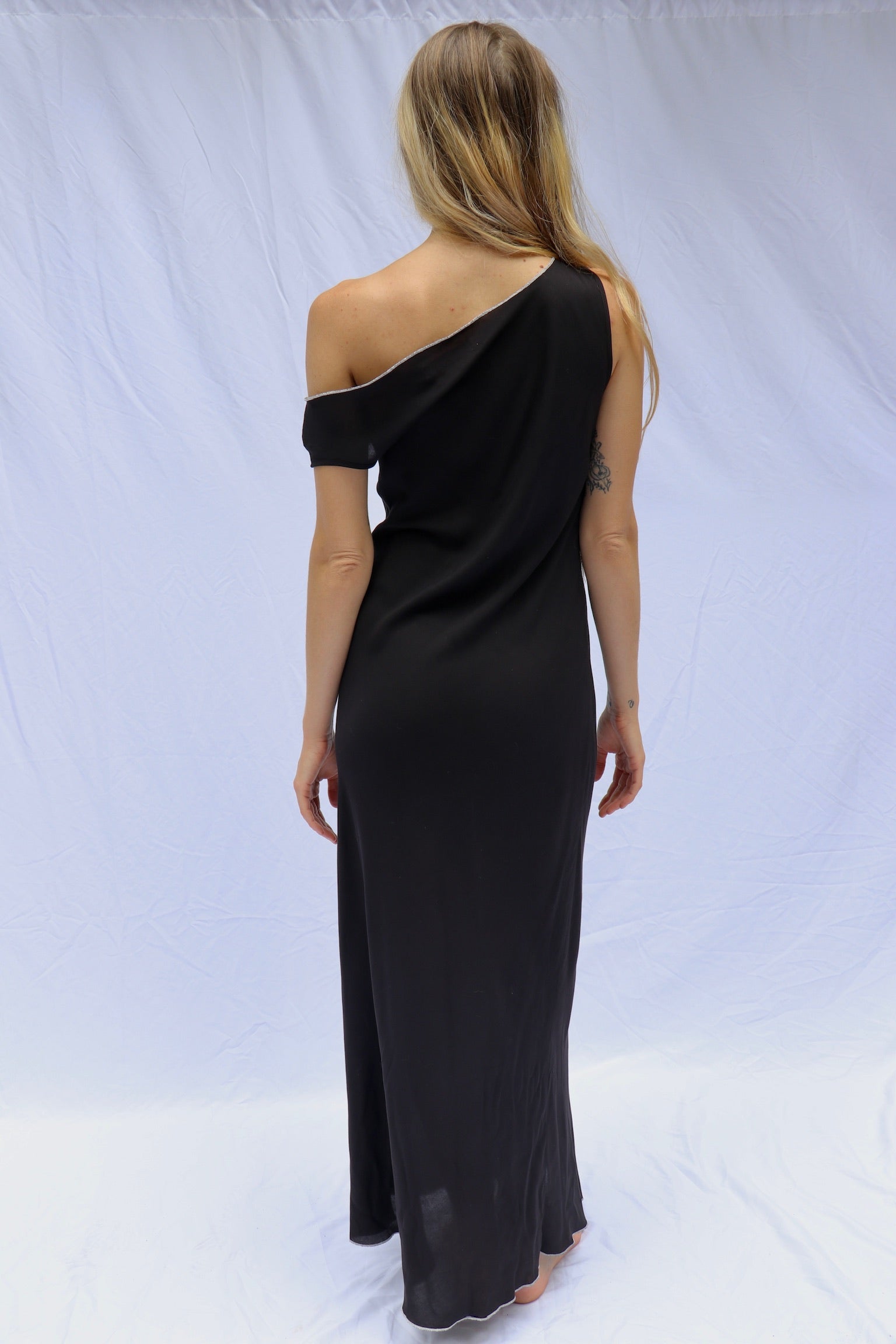 Discover The Laine Dress - a sexy floor-length, asymmetrical drape neck gown with a relaxed fit and one off-shoulder sleeve. The perfect European Summer dress. Featuring contrast merrow stitching and crafted from dead stock fabric, each piece is thoughtfully designed, cut, and sewn in LA. Embrace sustainable luxury with this unique and stylish dress.